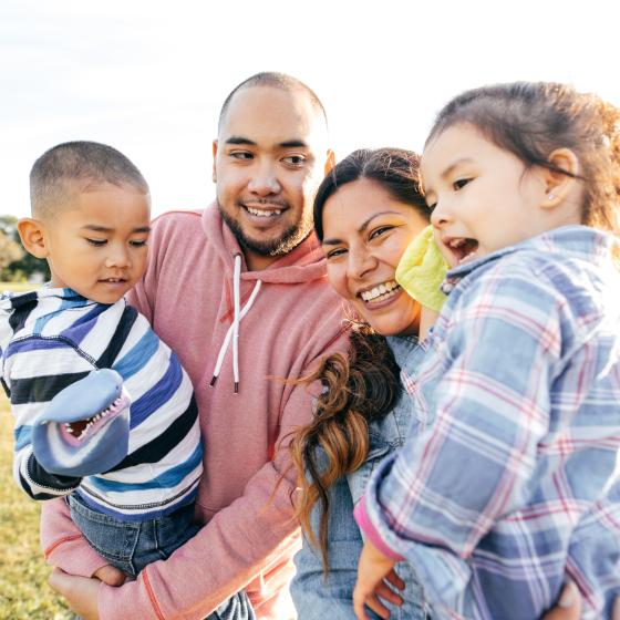 Photo of Hispanic family holding two young children