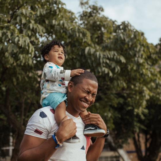 Photo of baby sitting on father's shoulders